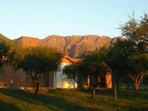 una casa con alberi di fronte a una montagna di Cabañas La Lucinda a Cortaderas