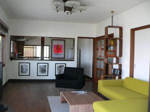尾道的住宿－尾道市坂之風酒店，客厅配有黄色的沙发和椅子