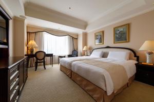 una camera d'albergo con un grande letto e una scrivania di Dai-ichi Hotel Tokyo a Tokyo