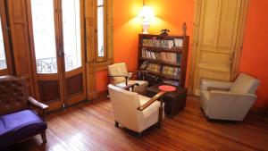 a living room with chairs and a book shelf at Hostel Brava mansa in Rosario