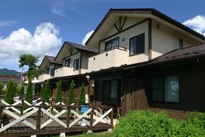 una casa con una valla de madera delante de ella en Villa May Queen, en Fujikawaguchiko