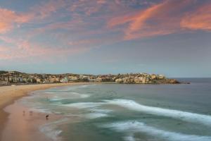 - une vue sur la plage avec des gens dans l'eau dans l'établissement The Village Bondi Beach, à Sydney