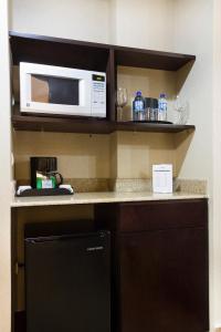 a kitchen with a microwave and a counter top at Best Western PREMIER Monterrey Aeropuerto in Monterrey