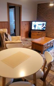 a living room filled with furniture and a tv at Stanley Village Waterfront Accommodation in Stanley