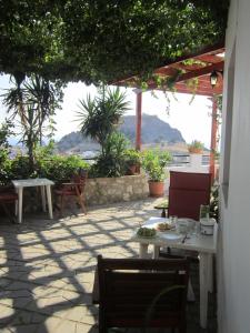 a patio with tables and chairs and a view of the ocean at Chrysa Studios in Lindos