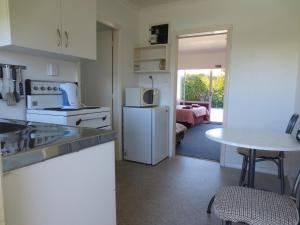 cocina con nevera blanca y mesa en Cambrian Lodge Motel, en Cambridge