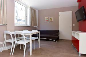 a dining room with a table and white chairs at Apartmenthouse Berlin - Am Görlitzer Park in Berlin