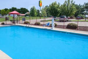 a large blue swimming pool in front of a fence at Super 8 by Wyndham Clinton in Clinton