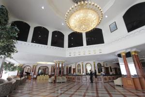 a large lobby with a chandelier and people standing in it at Royal Benja Hotel in Bangkok