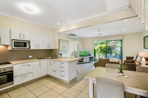 a kitchen and living room with a couch and a table at Terrapin Apartments in Noosaville