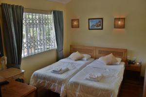 - une chambre avec 2 lits et une fenêtre dans l'établissement Bel Air Hotel, à Victoria