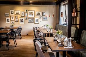 a restaurant with wooden tables and chairs and pictures on the wall at Landhaus Stümpelstal in Marburg an der Lahn