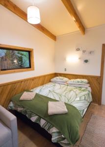 two beds in a room with a window at Te Nikau Retreat in Punakaiki