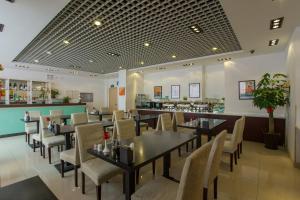 a dining room with tables and chairs in a restaurant at Jinjiang Inn Beijing Olympics Park in Beijing