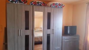 a large wooden cabinet with a television in a bedroom at Pensiunea Popan in Şieu