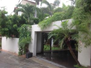 a white building with a courtyard with palm trees at Silvikris Villa in Colombo +29 photos