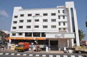 Hotel Vijayentra في بونديتْشيري: مبنى أبيض فيه شاحنة متوقفة أمامه