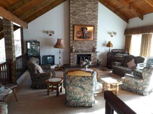 a living room with couches and a fireplace at Arbuckle House in Himeville