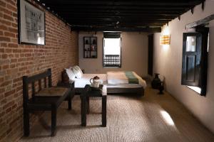 a bedroom with a bed and a table and a chair at Peacock Guest House in Bhaktapur