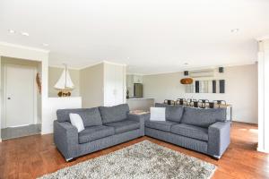 a living room with two couches and a kitchen at 'Hope House' - Encounter Bay in Kilki