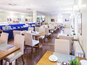 een eetkamer met tafels en stoelen en een cafetaria bij Hotel Domicil Hamburg by Golden Tulip in Hamburg