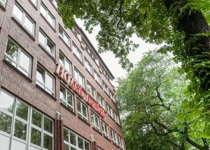 een rood bord aan de zijkant van een bakstenen gebouw bij Hotel Domicil Hamburg by Golden Tulip in Hamburg