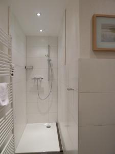 W białej łazience z przeszklonymi drzwiami znajduje się prysznic. w obiekcie Landhaus Stümpelstal w mieście Marburg
