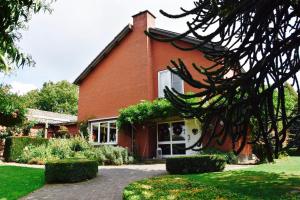 a red brick house with bushes in front of it at De Hagendoorn in Moorveld