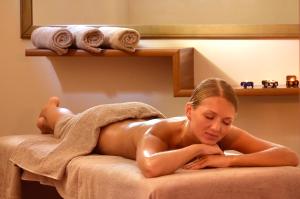 a naked woman laying on a bed in a towel at City's Hill Hotel in Kuşadası