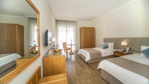 a hotel room with two beds and a television at AlQasr Metropole Hotel in Amman