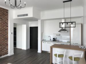 a kitchen with white cabinets and a table and chairs at GIA Suites in Caracal