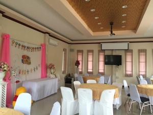 een feestzaal met tafels en stoelen en een tv bij Tararin Resort in Ban Nong Nok Khian