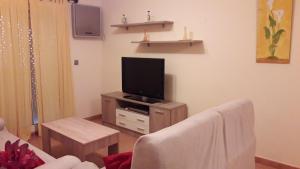 sala de estar con sofá y TV en Apartamento con Piscina, en Tarifa