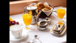 una mesa de desayuno con zumo de naranja y una cesta de pan. en Hostal Playa Herradura, en Coquimbo