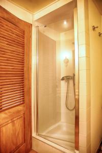 y baño con ducha y puerta de cristal. en Apartment Cali Elina en Riquewihr