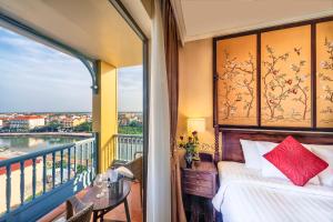 a bedroom with a bed and a balcony with a view at Little Residence- A Boutique Hotel & Spa in Hoi An