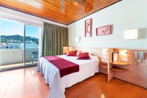 a hotel room with a bed and a large window at Hotel Xaine Park in Lloret de Mar