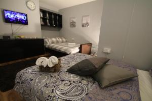 a bedroom with a bed with towels on it at Molesey Apartments in London