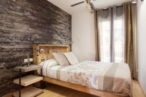 sypialnia z łóżkiem i ścianą z cegły w obiekcie Apartment Beach Front Canet w mieście Canet de Mar