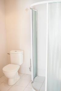 a bathroom with a toilet and a glass shower at Domus Hotel in Birštonas