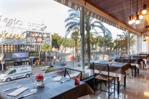 a restaurant with tables and a view of a street at Hotel Xaine Park in Lloret de Mar