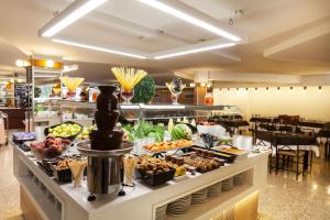 a buffet line with fruits and vegetables in a restaurant at Hotel Xaine Park in Lloret de Mar