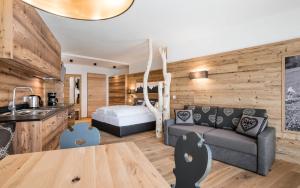 a kitchen and a living room with a couch and a bed at Niederthalerhof Chalets in Bressanone