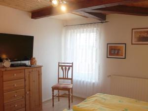 - une chambre avec un lit, une télévision et une chaise dans l'établissement Modern Apartment near Sea in Tranewitz, à Tarnewitz