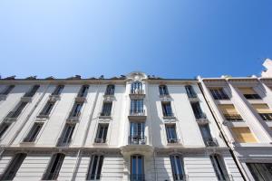 un edificio blanco con un reloj encima en Caravel, en Niza