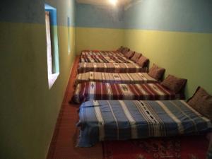 een kamer met drie bedden in een kamer bij Gite Ousalem in Asni