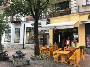 a restaurant with wooden tables in front of a building at Apartamenty Góralska Pasja Krupówki 37 in Zakopane