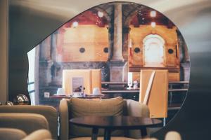 فندق كاسترو في مدينة هيراكيلون: مرآة تعكس غرفة مع الكراسي والطاولات