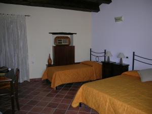 a bedroom with two beds and a tv on the wall at Domus Lilio in Petralia Sottana