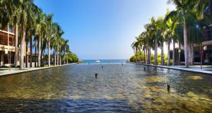 une rue bordée de palmiers et d'une piscine d'eau dans l'établissement Yalong Bay Mangrove Tree Resort, à Sanya